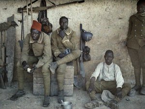 Senegalští vojáci sloužící ve francouzské armádě jako pěšáci odpočívající v místnosti se zbraněmi a vybavením, Saint-Ulrich, department Haut-Rhin, Alsasko, Francie, 16. června 1917 (autochrom)